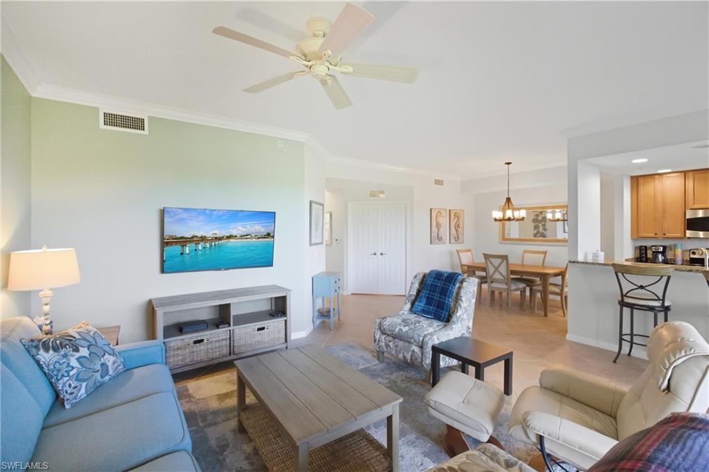 9844 Venezia Circle, Unit 714 Naples, FL 34113 - Photo 10 of 50 a living room with furniture and a flat screen tv