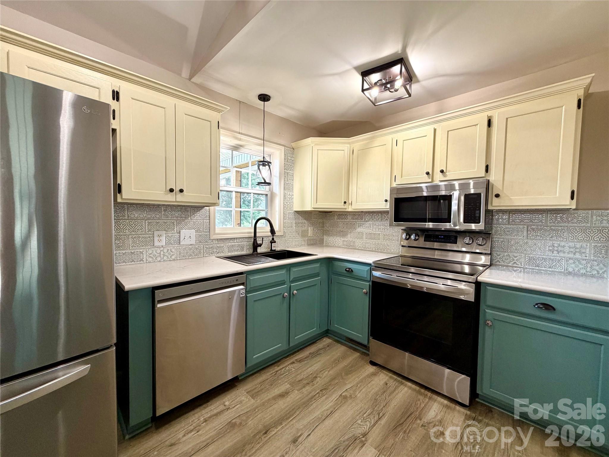 1027 Tabor Road Olin, NC 28660 - Photo 5 of 43 a kitchen with stainless steel appliances granite countertop a sink stove and refrigerator