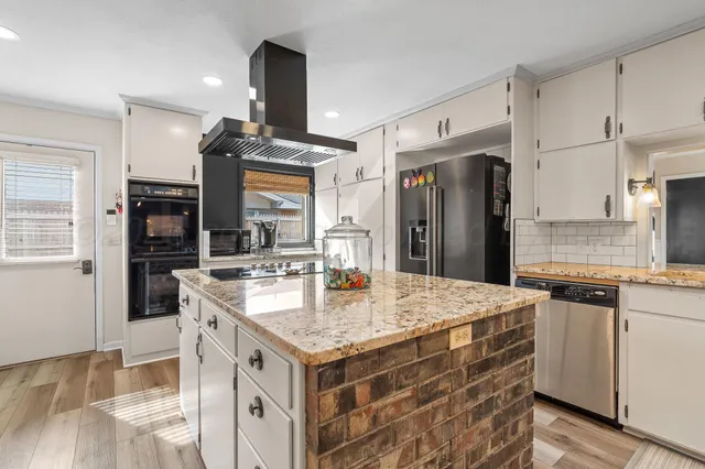 a kitchen with stainless steel appliances granite countertop a sink and a refrigerator