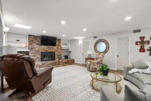 a living room with furniture a fireplace and a flat screen tv