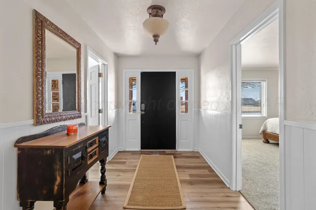 a hallway with wooden floor and a chandelier