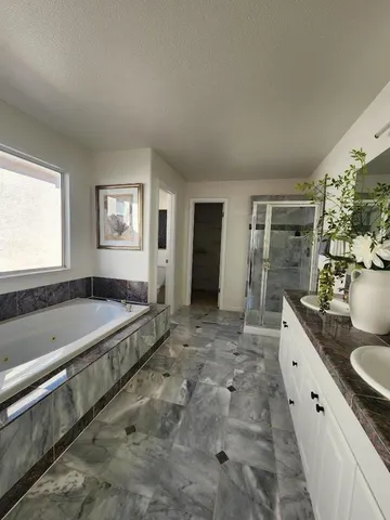 a spacious bathroom with a granite countertop tub sink and mirror