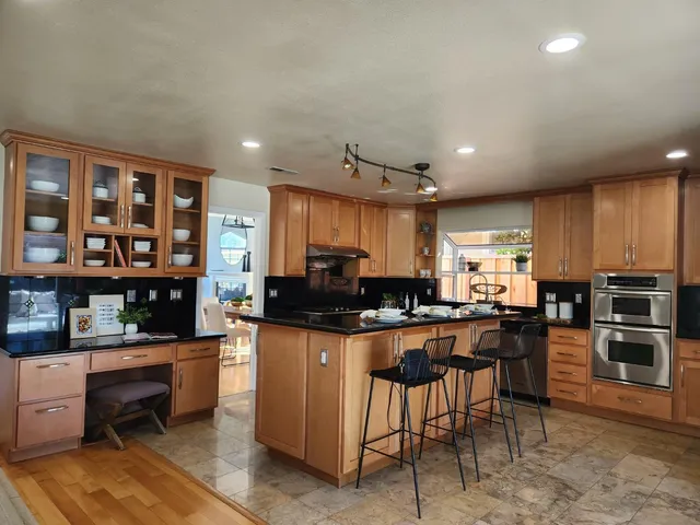 a kitchen with stainless steel appliances kitchen island granite countertop a stove and cabinets