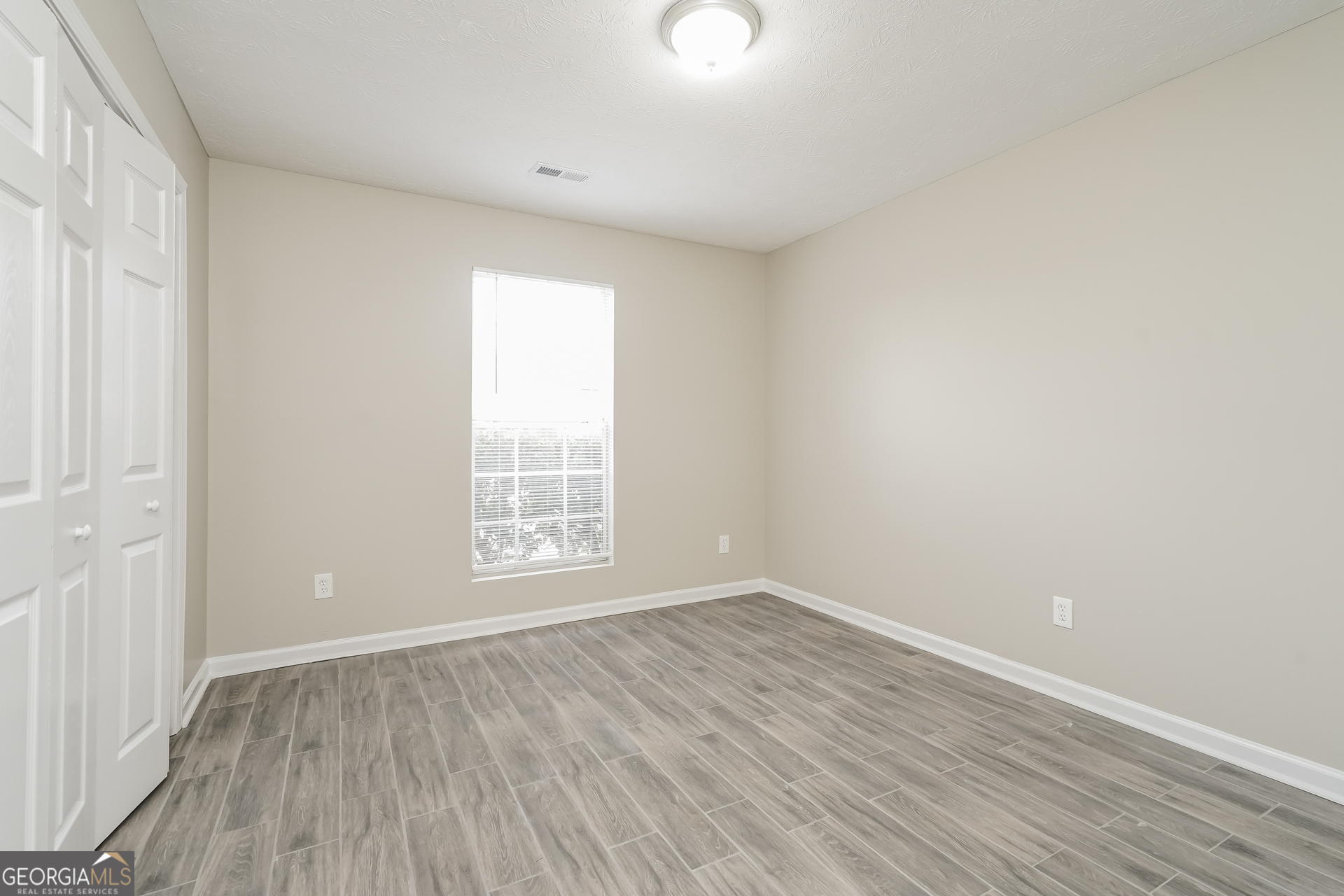 145 Fairclift Drive Covington, GA 30016 - Photo 12 of 16 wooden floor in an empty room with a window
