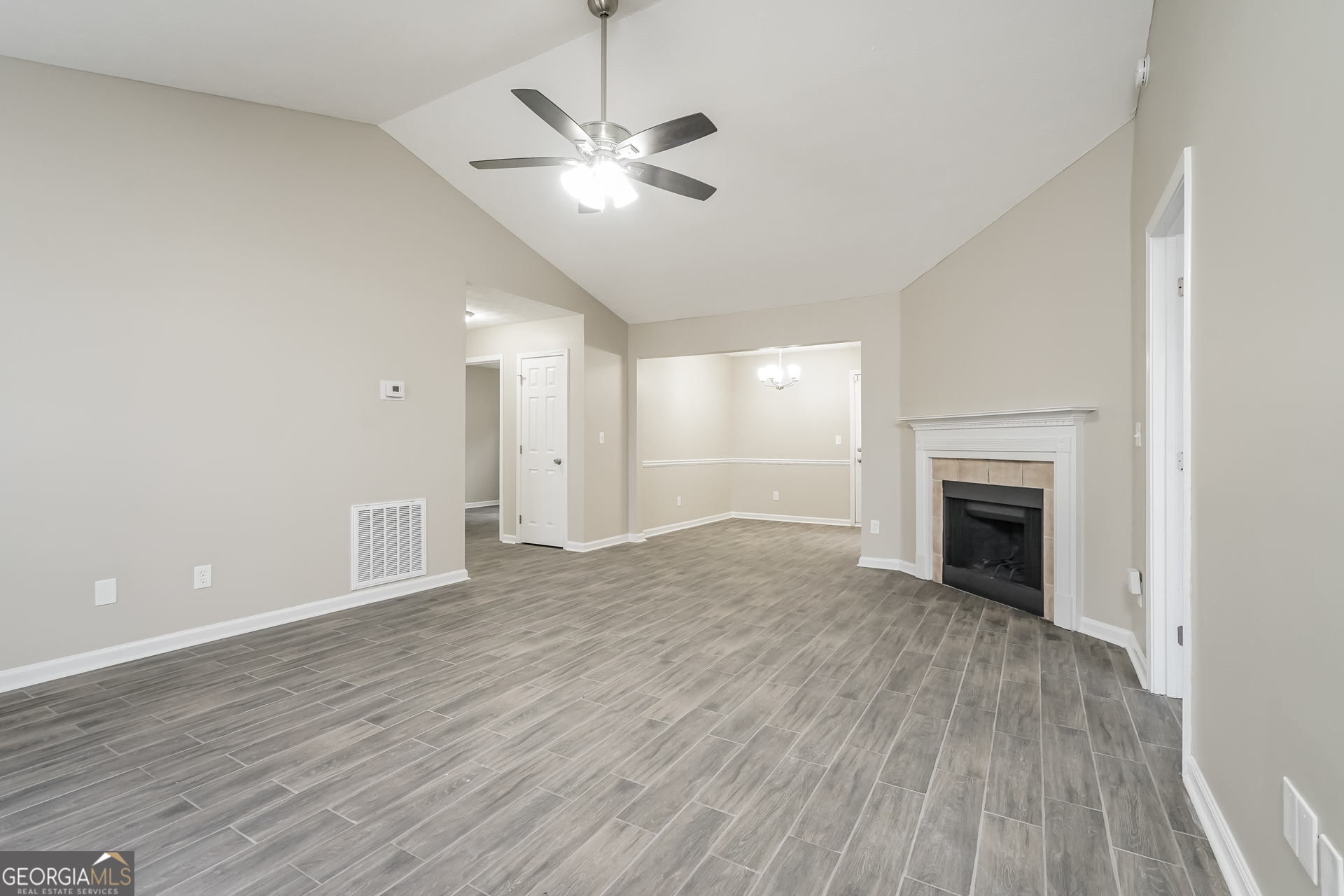 145 Fairclift Drive Covington, GA 30016 - Photo 3 of 16 an empty room with wooden floor fireplace and windows