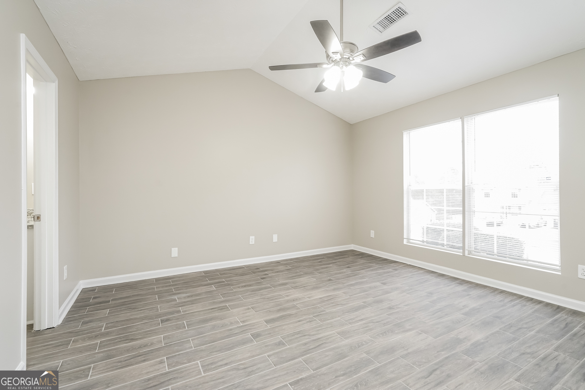 145 Fairclift Drive Covington, GA 30016 - Photo 9 of 16 an empty room with wooden floor and windows