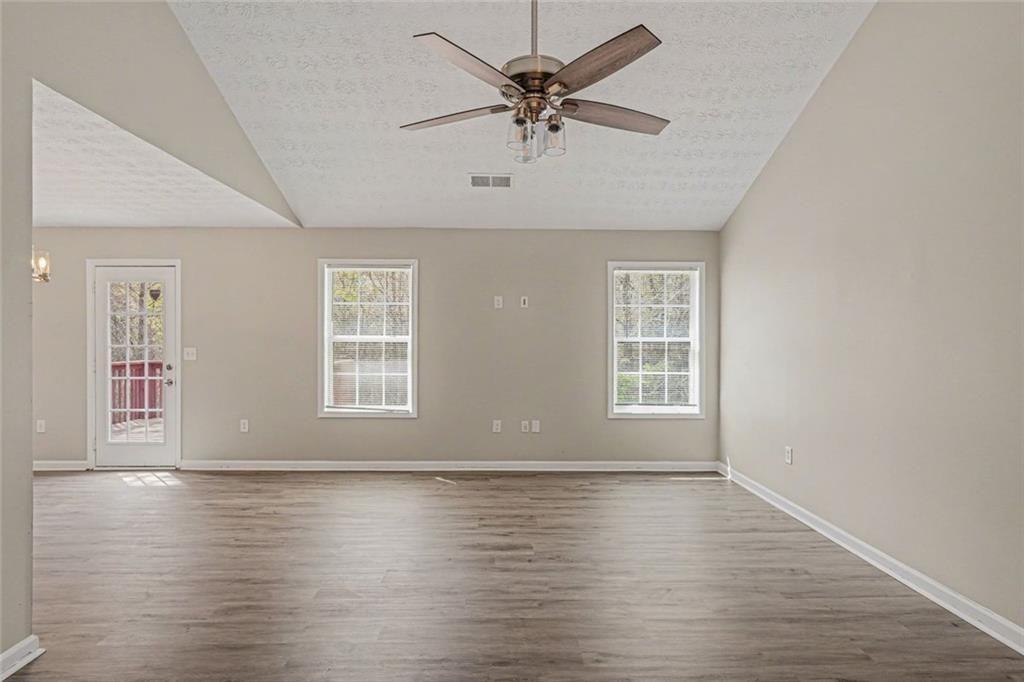 10 Wilbur Way Covington, GA 30016 - Photo 4 of 22 an empty room with wooden floor and windows with curtains
