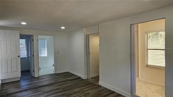 a view of empty room with wooden floor