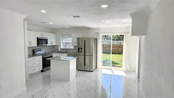 a kitchen with a refrigerator and a stove top oven