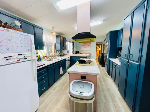 a kitchen with stainless steel appliances a stove a refrigerator a sink dishwasher with a dining table and chairs