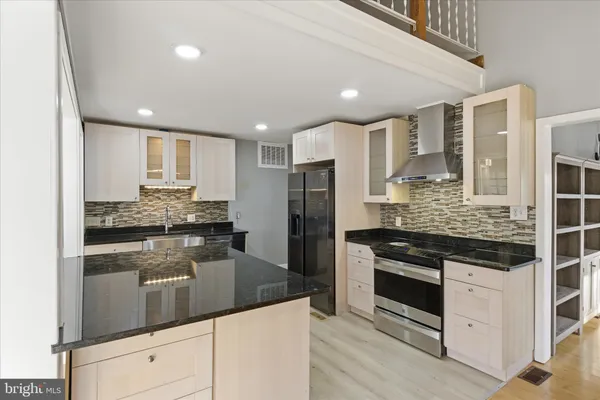a kitchen with stainless steel appliances granite countertop a stove and a refrigerator