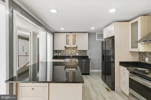 a kitchen with refrigerator a stove and a sink