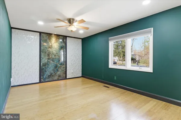 an empty room with closet and a chandelier fan