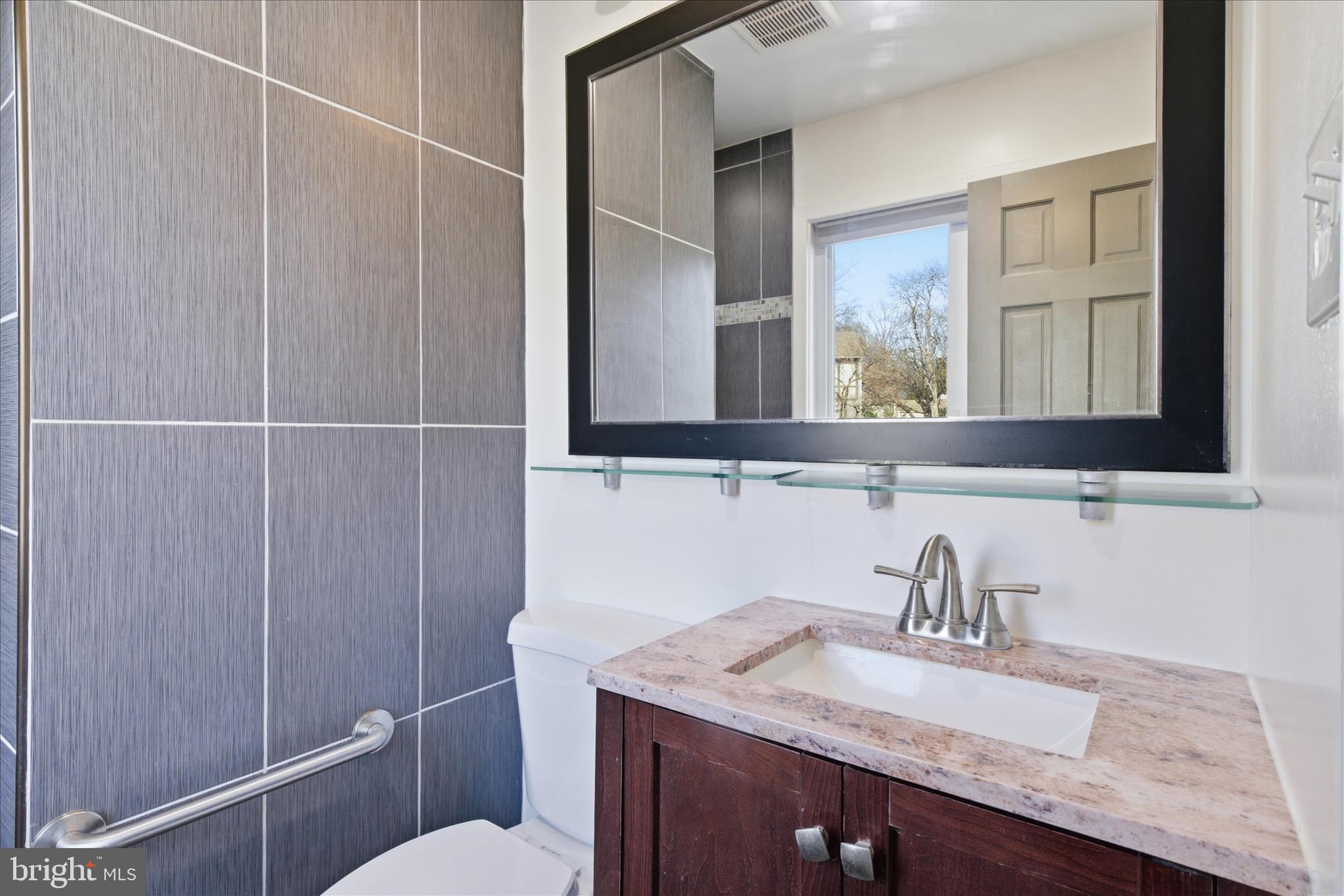 5515 Westcliff Court Burke, VA 22015 - Photo 20 of 47 a bathroom with a granite countertop sink a mirror and a toilet