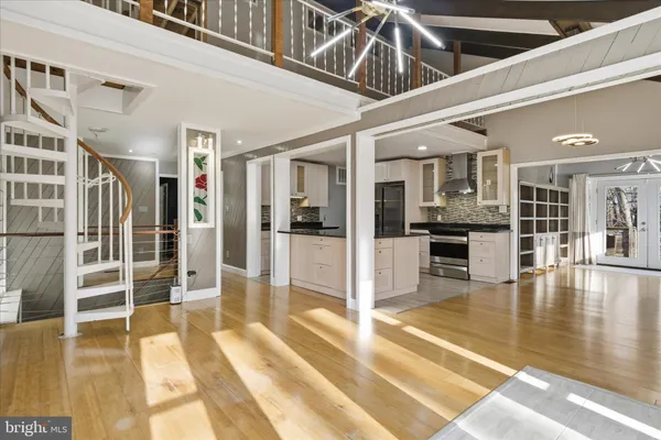 a view of an entryway with wooden floor and a kitchen view