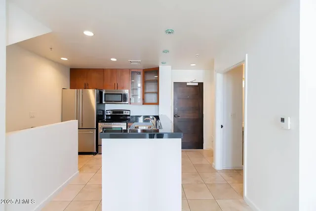 a kitchen with stainless steel appliances kitchen island granite countertop a refrigerator and a stove