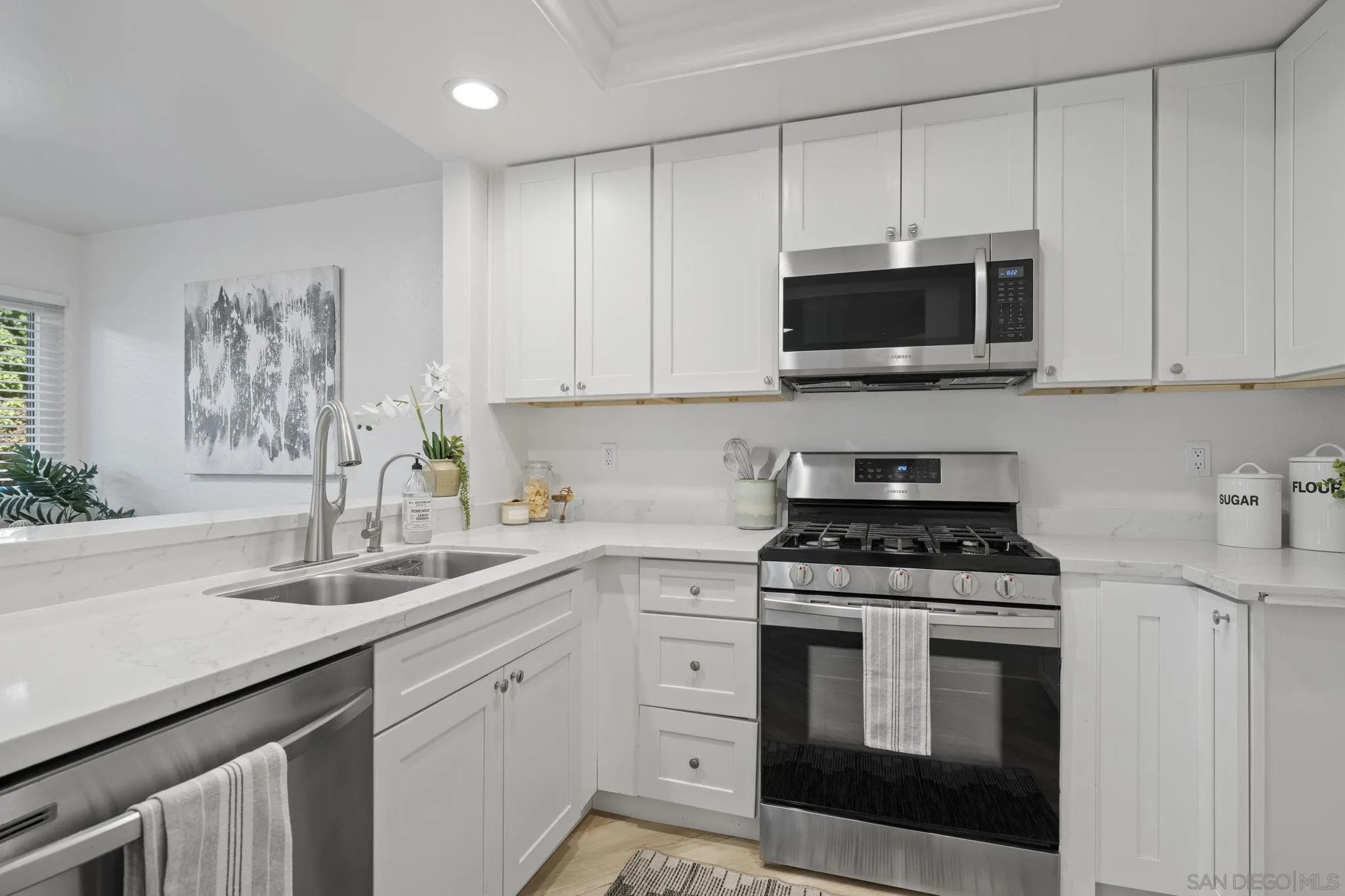 3002 Blue Oak Court Spring Valley, CA 91978 - Photo 8 of 23 a kitchen with white cabinets and stainless steel appliances