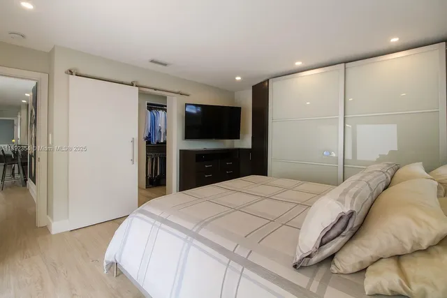 a bedroom with a bed and a flat screen tv