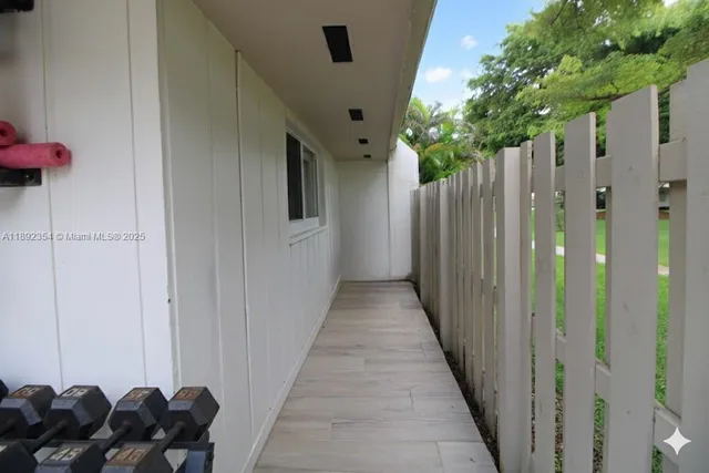 a view of a house with backyard and wooden fence