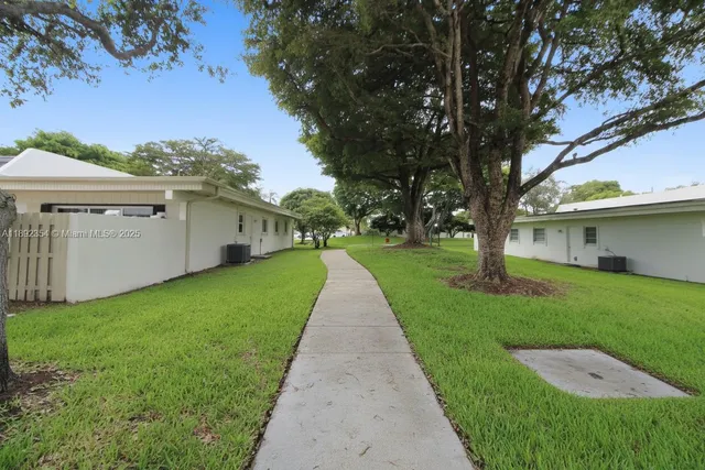 a view of a yard with a house and a large tree