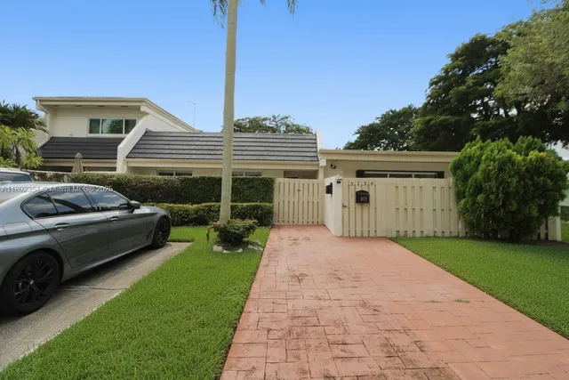 a front view of a house with a garden and plants