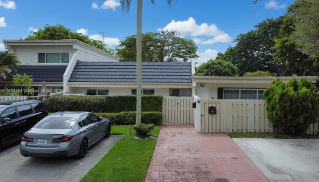 an aerial view of residential houses with outdoor space and trees