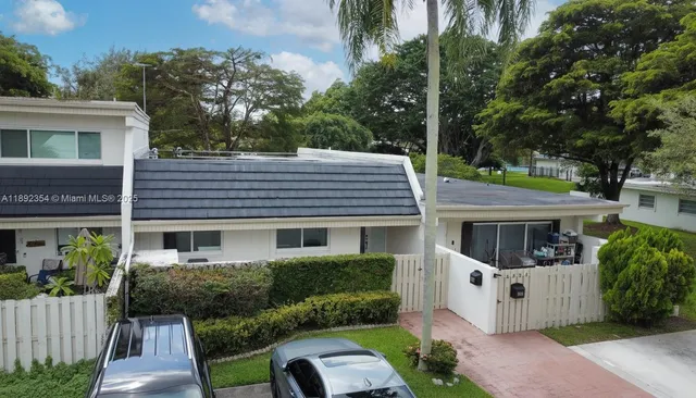a front view of a house with a garden and plants