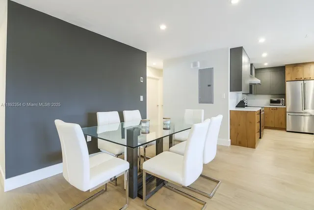 a living room with furniture a refrigerator and kitchen view