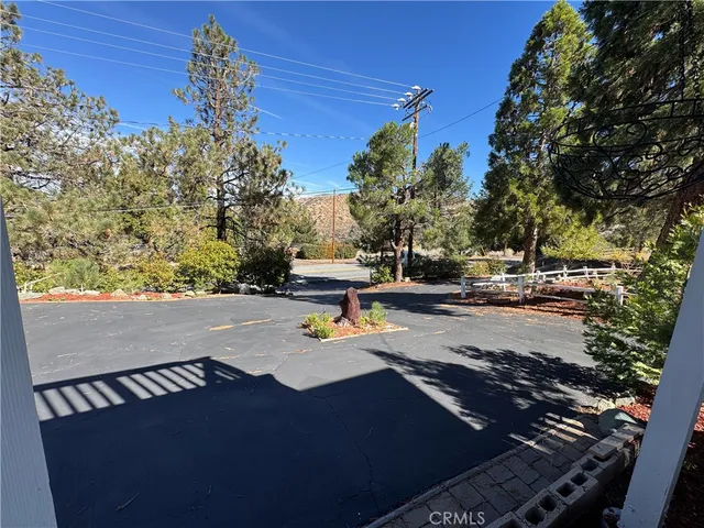 a view of a brick house with plants and trees in front of it