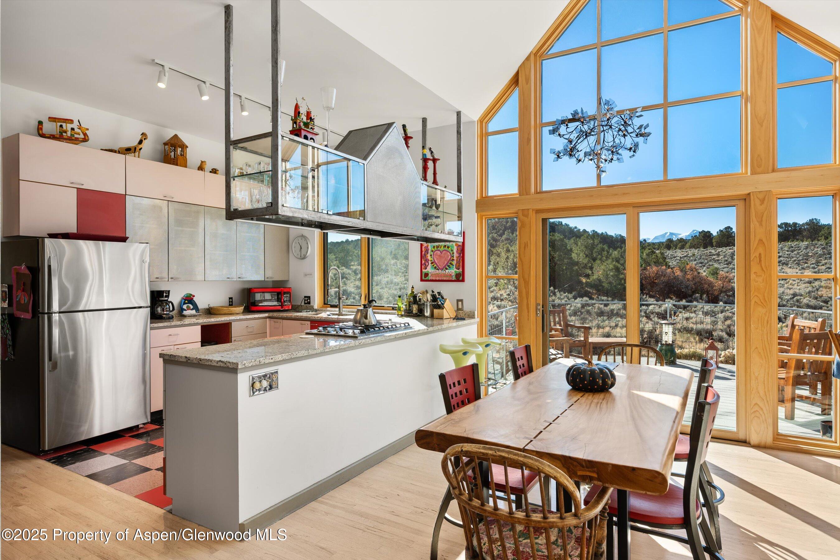 525 Cactus Flats Road Carbondale, CO 81623 - Photo 11 of 50 a kitchen with stainless steel appliances granite countertop a stove a refrigerator a dining table and chairs with wooden floor