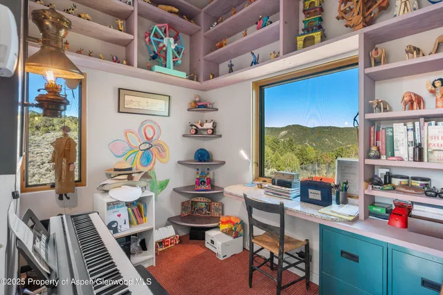 a work room with furniture a rug and a window