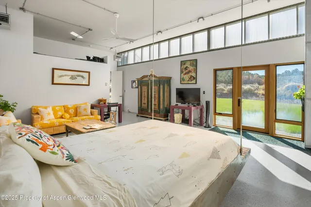 a spacious bedroom with a bed couch and a large window