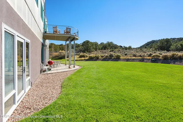 a view of a house with a big yard and large trees