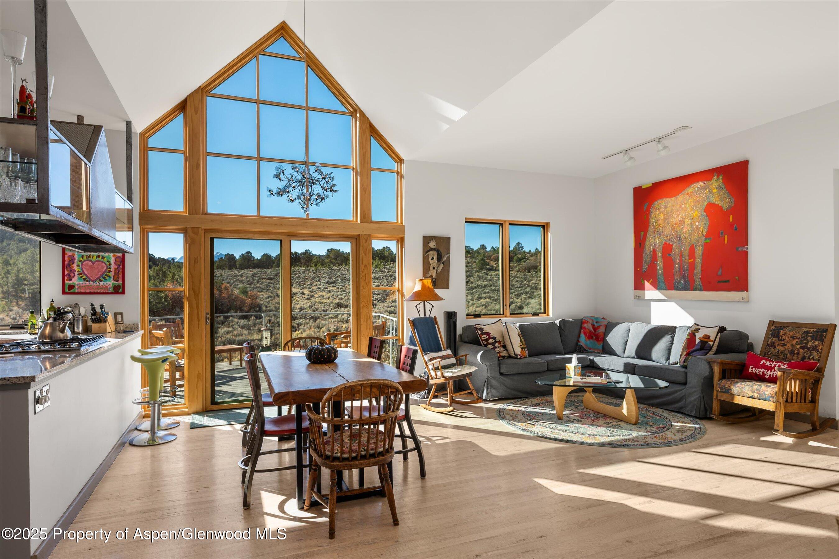 525 Cactus Flats Road Carbondale, CO 81623 - Photo 5 of 50 a living room with furniture a floor to ceiling windows and a dining table