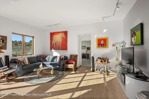 a living room with furniture a flat screen tv and a large window