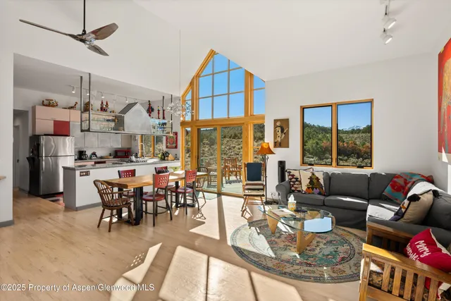 a living room with fireplace furniture and a large window