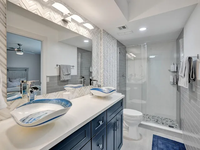 a bathroom with a sink a toilet a mirror and shower