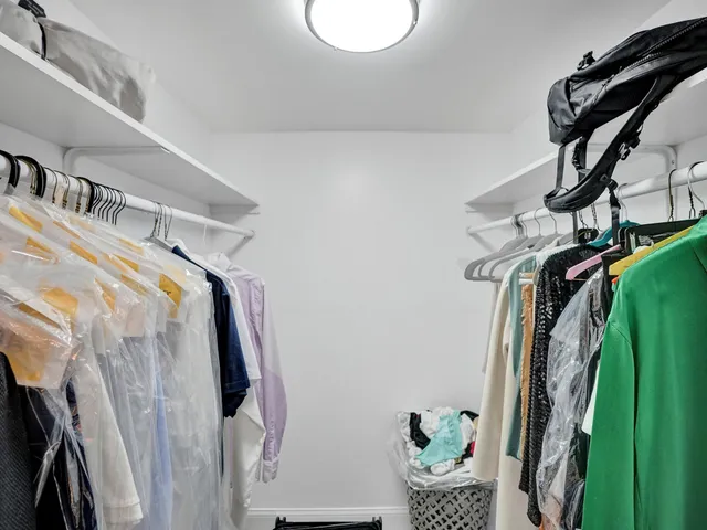a view of walk in closet with clothes and shoes