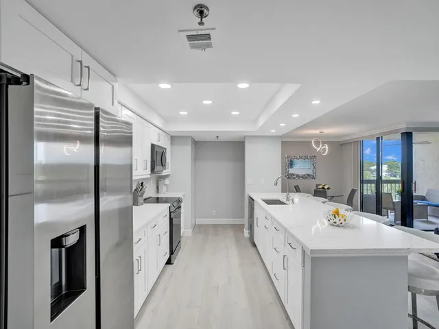 a large white kitchen with a large window
