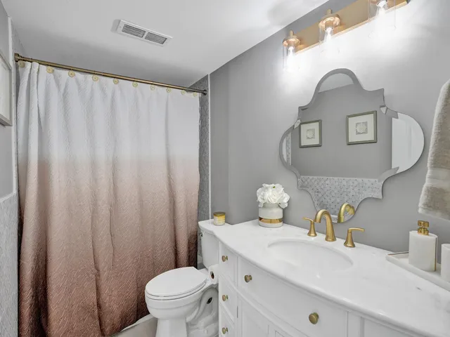 a bathroom with a sink a toilet and a mirror