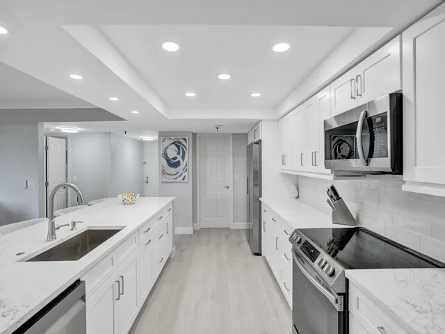 a kitchen with stainless steel appliances kitchen island granite countertop a sink and cabinets