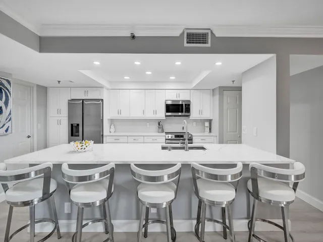 a kitchen with stainless steel appliances a table and chairs in it
