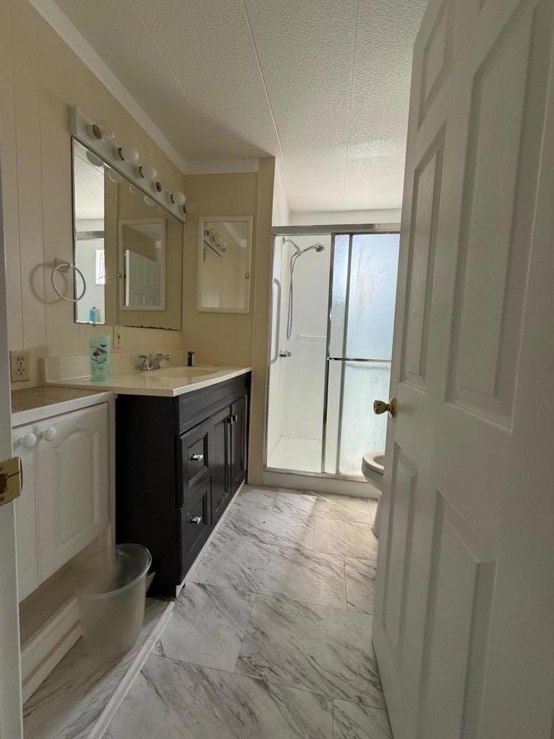 12350-147 Christensen Road, Unit 147 Salinas, CA 93907 - Photo 7 of 15 a bathroom with a double vanity sink a mirror and a shower