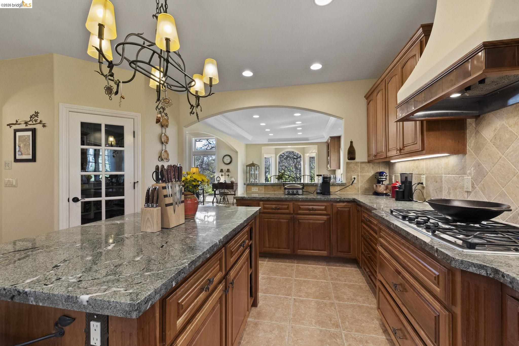 18558 Olov Road Sonora, CA 95370 - Photo 18 of 45 a kitchen with stainless steel appliances granite countertop a sink a stove and a wooden cabinets
