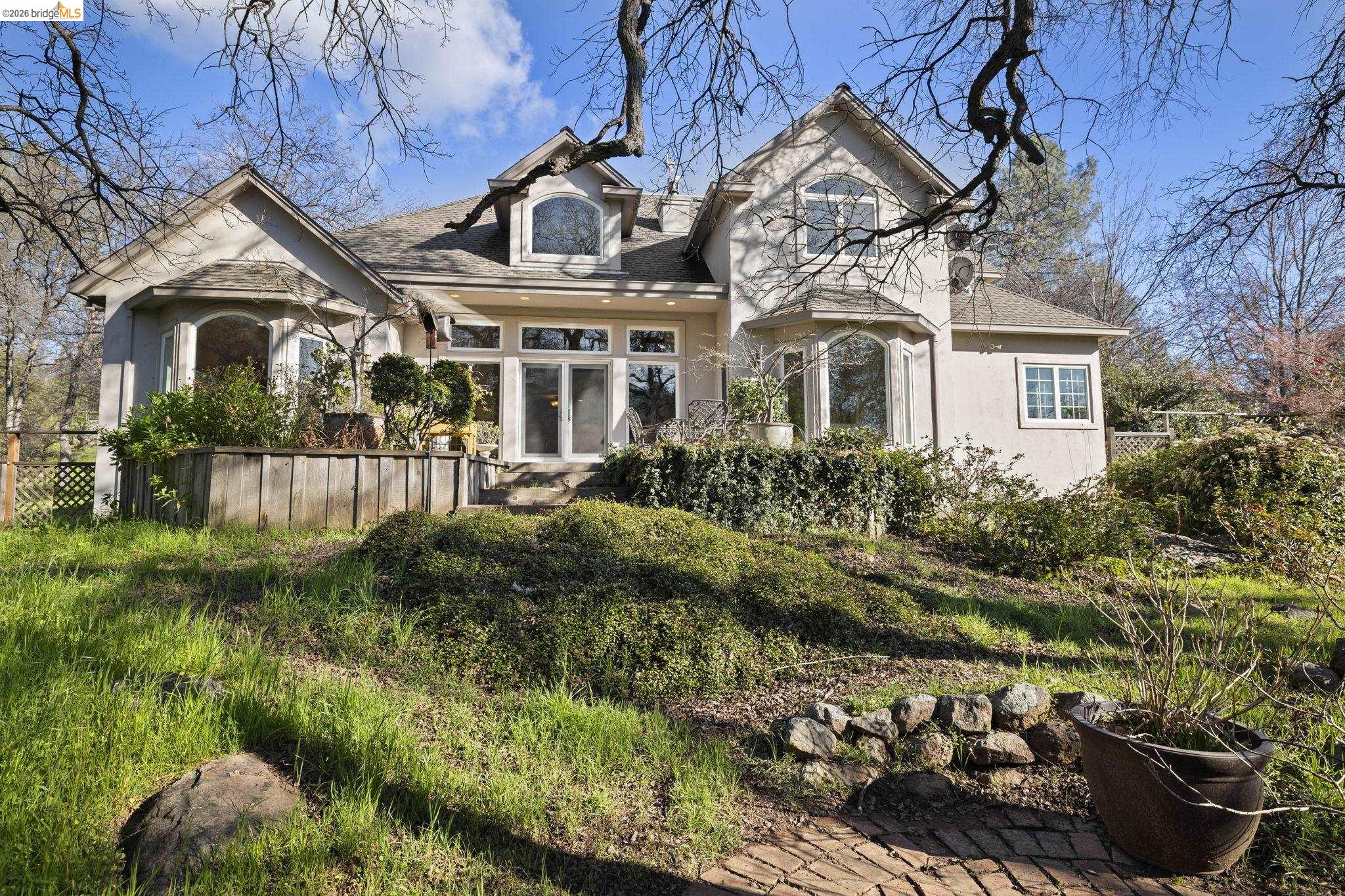 18558 Olov Road Sonora, CA 95370 - Photo 40 of 45 a front view of a house with a yard and potted plants
