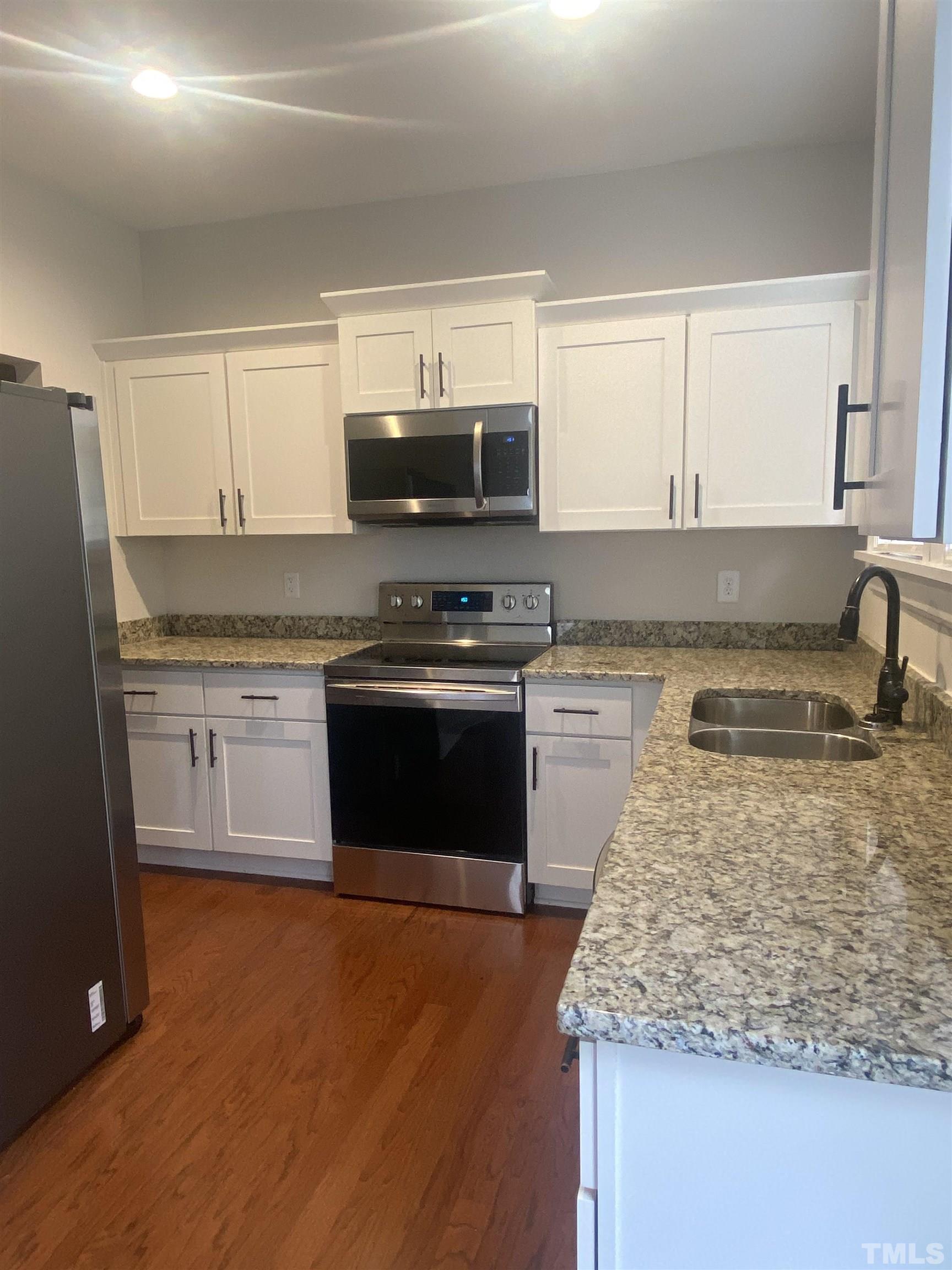 16 Turner Street Raleigh, NC 27607 - Photo 3 of 8 a kitchen with stainless steel appliances granite countertop a stove a sink and a microwave