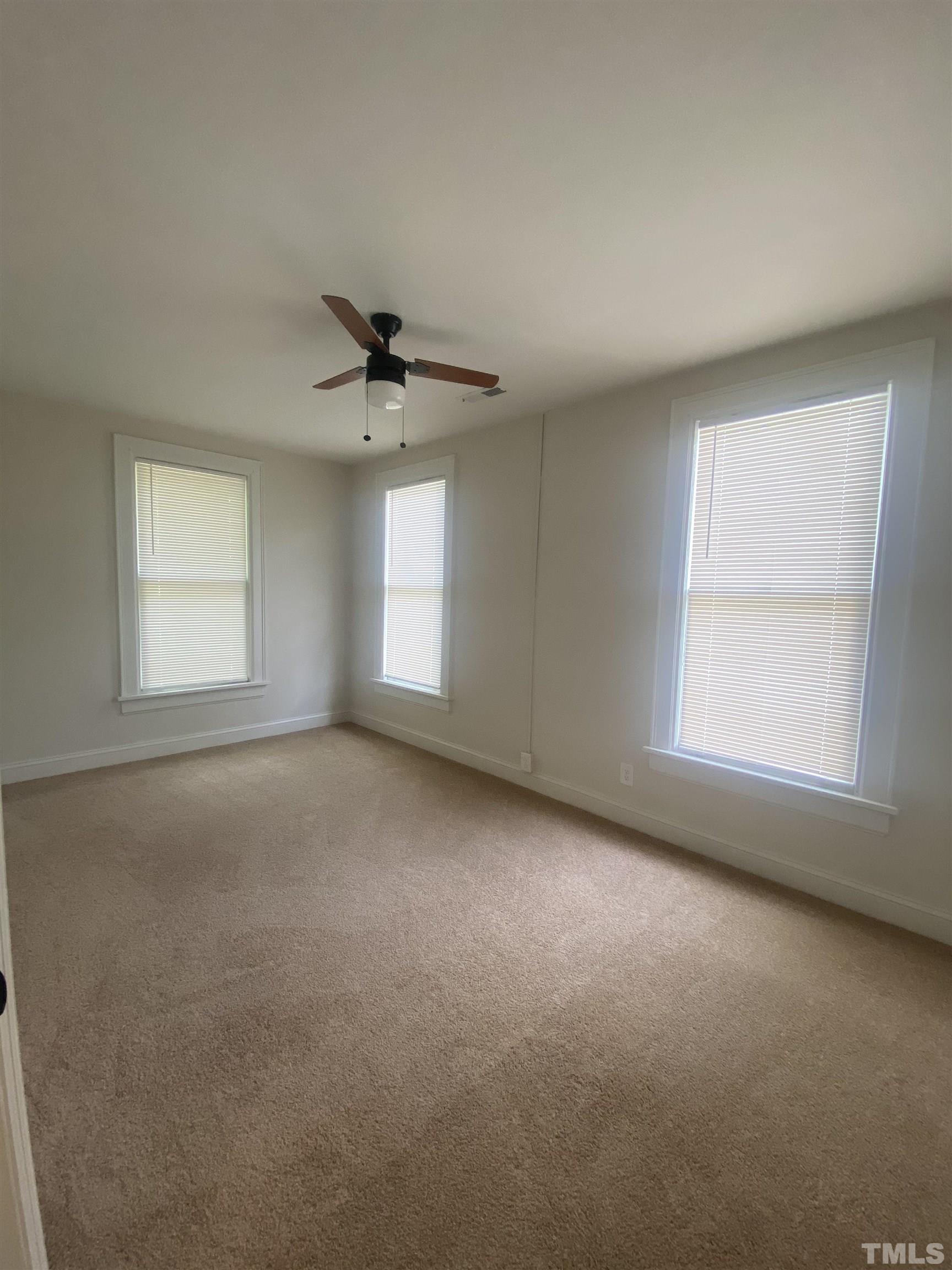 16 Turner Street Raleigh, NC 27607 - Photo 6 of 8 an empty room with a window and a ceiling fan