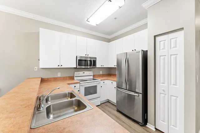 a kitchen with stainless steel appliances granite countertop a refrigerator sink and stove