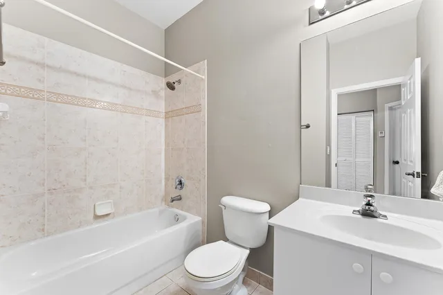 a bathroom with a toilet a sink a mirror a bathtub and vanity