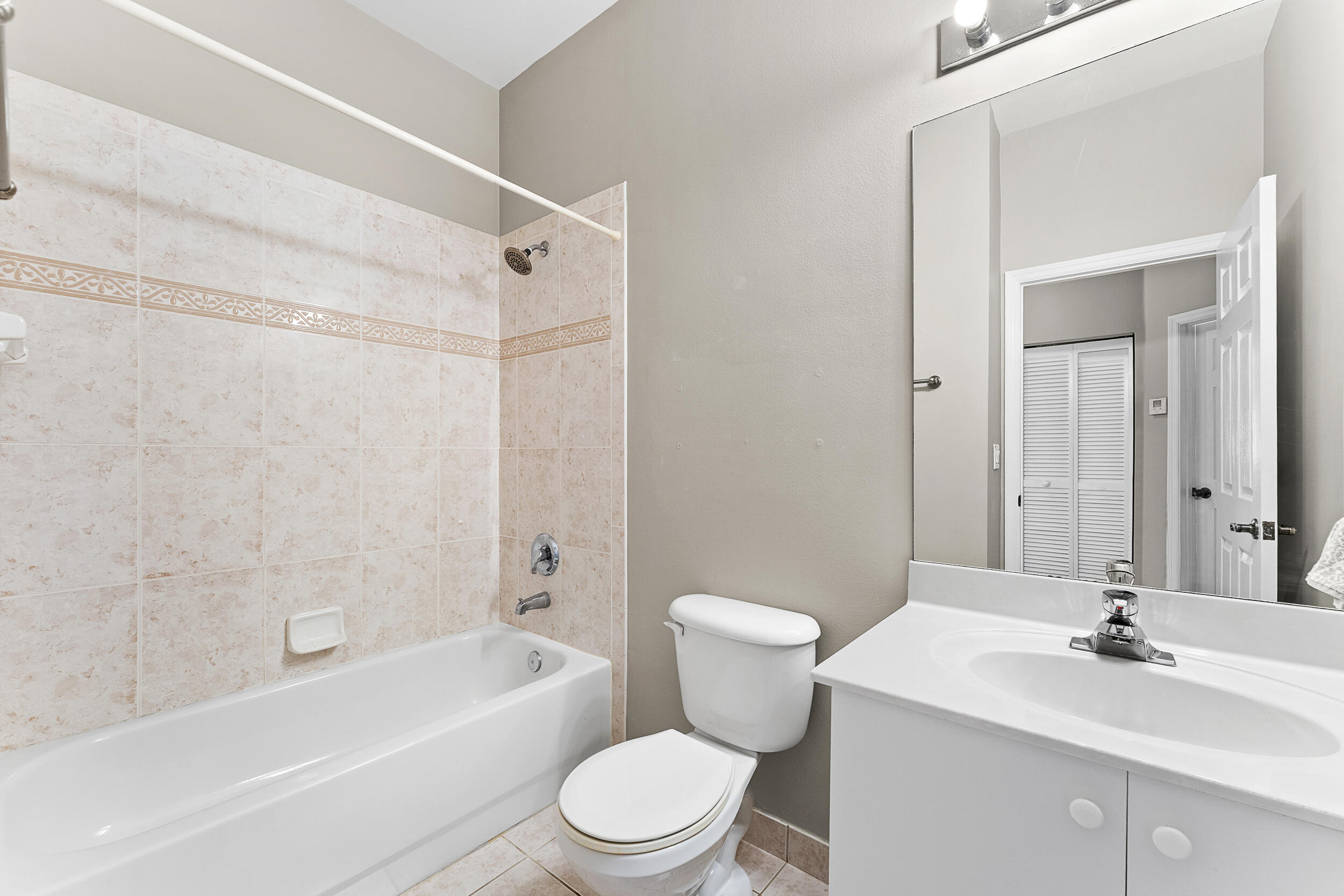 115 Lighthouse Circle, Unit C Tequesta, FL 33469 - Photo 18 of 29 a bathroom with a toilet a sink a mirror a bathtub and vanity